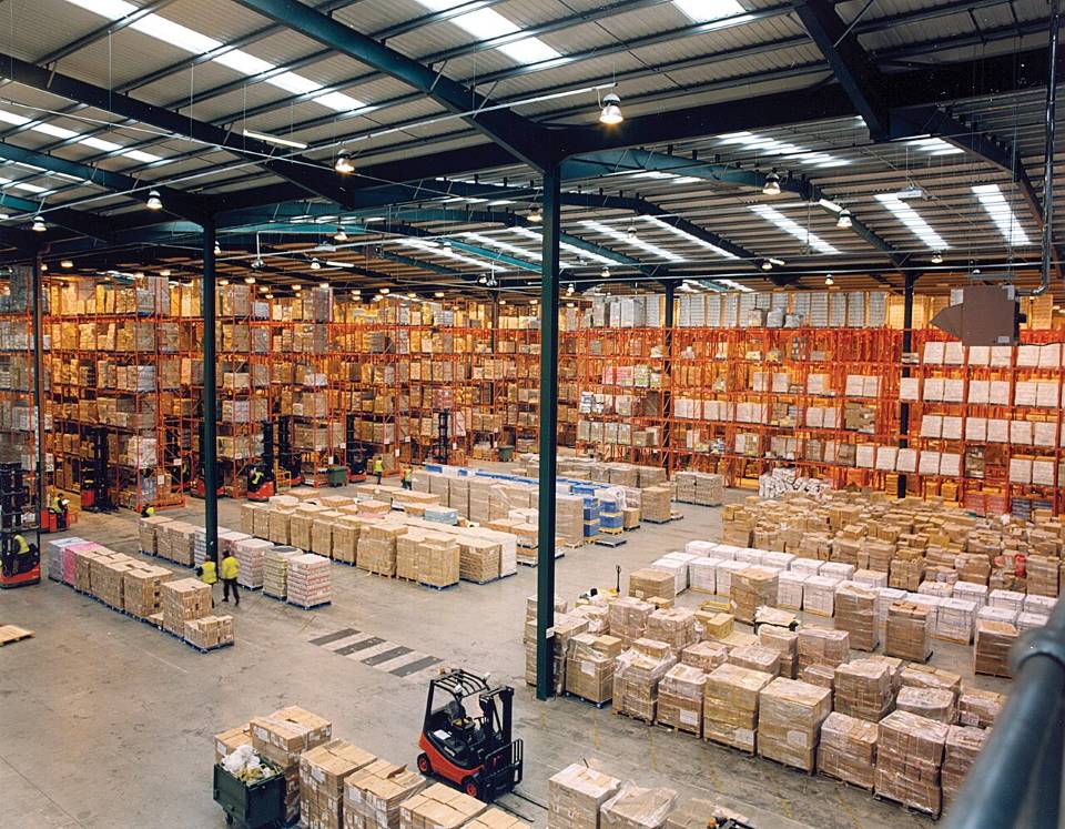 Bodega con racks de pallets y grúa horquilla.
