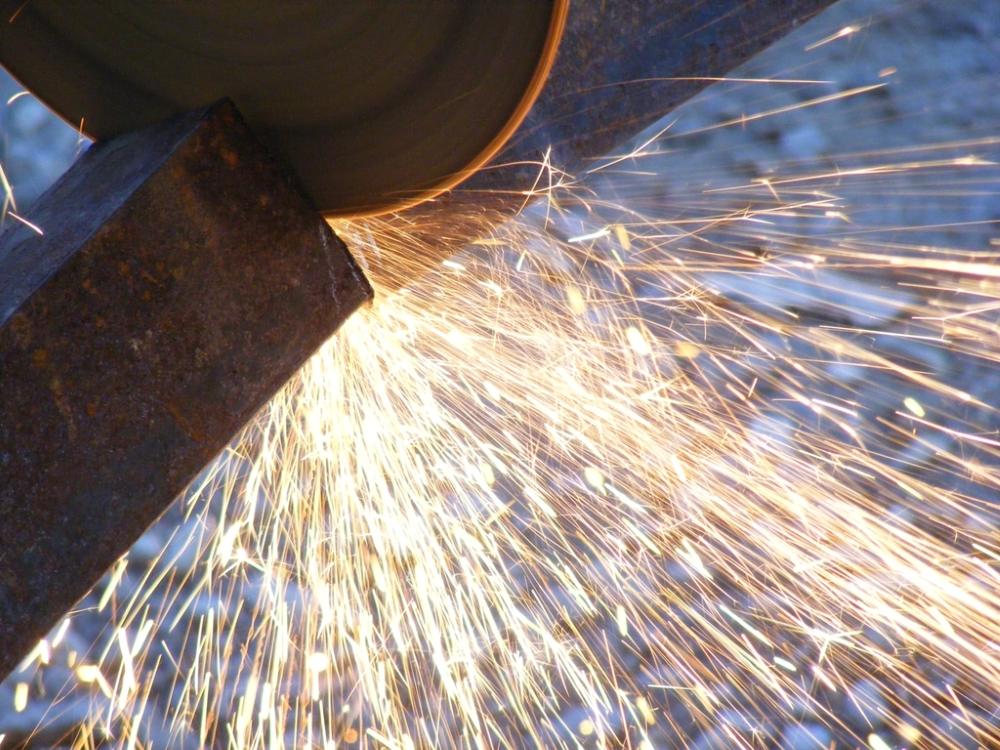 Disco de corte de una herramienta eléctrica cortando un perfil de acero entre chispas.